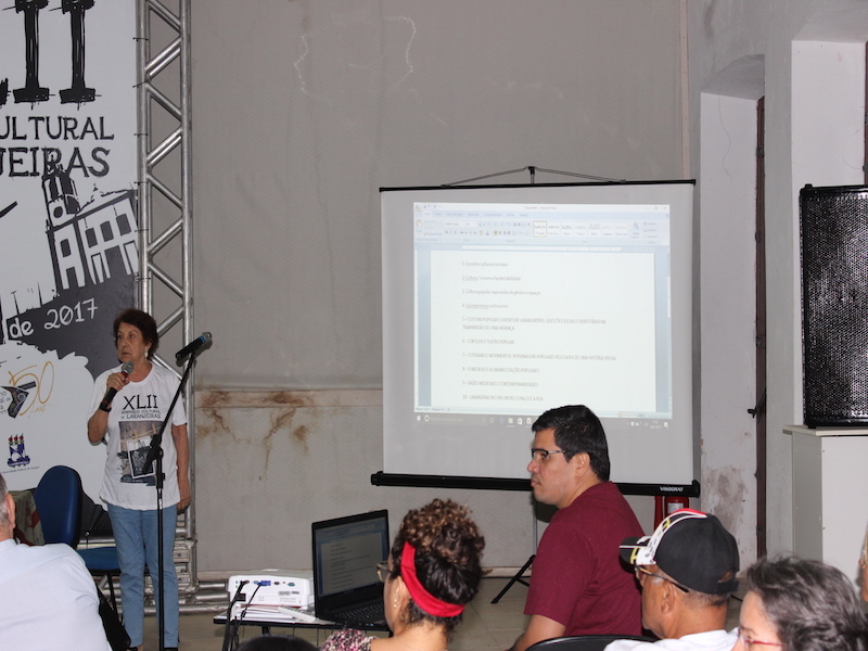 Foto da professora Maria Augusta iniciando votação da escolha do tema do XLIII Encontro Cultural de Laranjeiras.